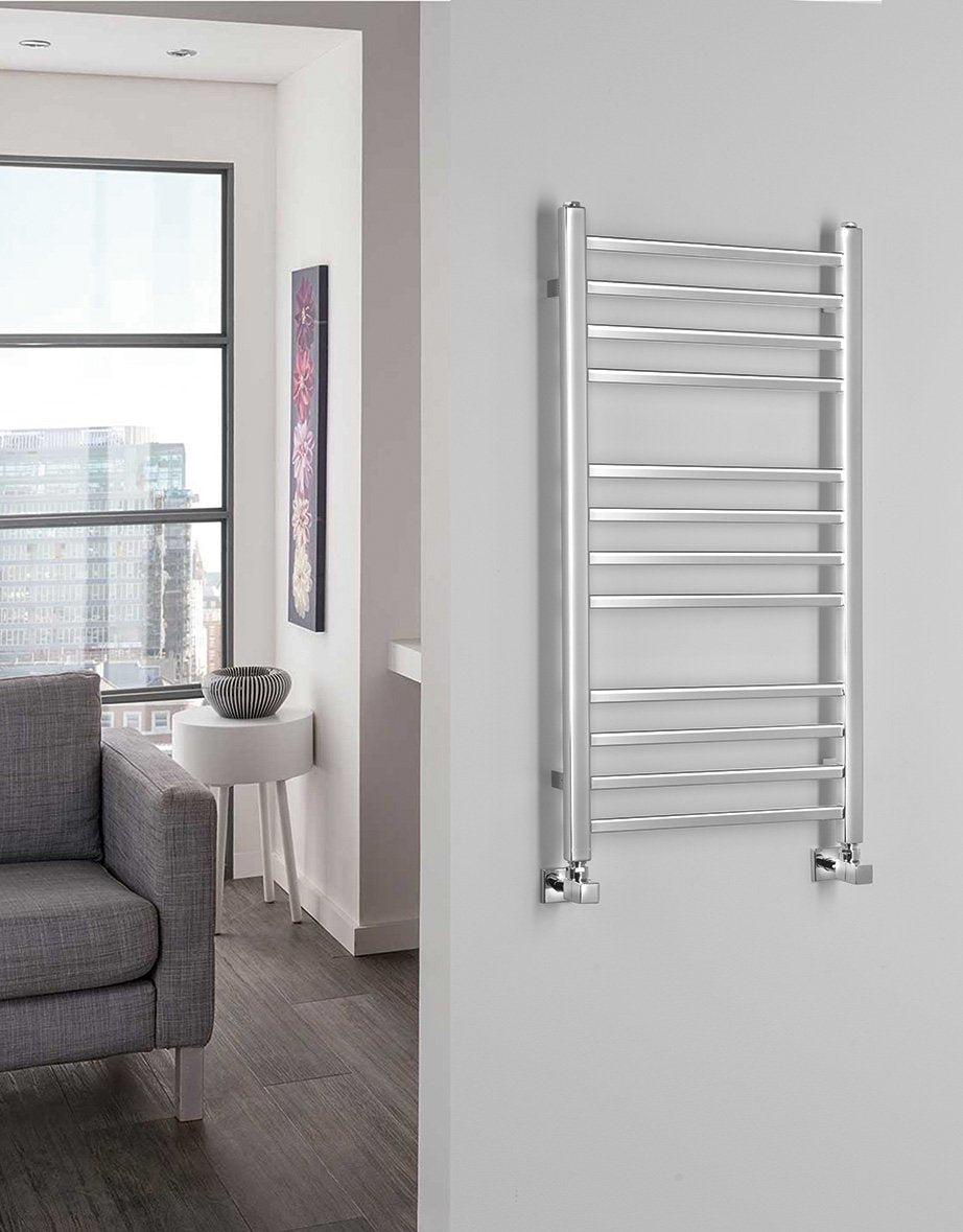 Kopalniški radiator SAPHO METRO, 450 × 890 mm, kromiran – izdelek 0411-03 – primer postavitve v prostoru. Na sliki so prikazani tudi priključni ventili; vsebina nakupa je navedena v opisu. Pohištvo in oprema prostora nista vključena v nakup.