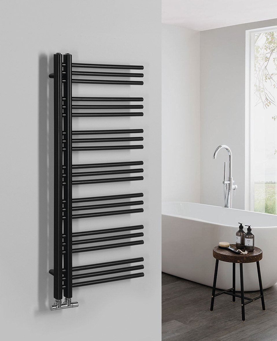 Kopalniški radiator SAPHO DORLION, 500 × 1200 mm, mat črn – izdelek 1130-21 – primer postavitve v prostoru. Na sliki so prikazani tudi priključni ventili; vsebina nakupa je navedena v opisu. Pohištvo in oprema prostora nista vključena v nakup.